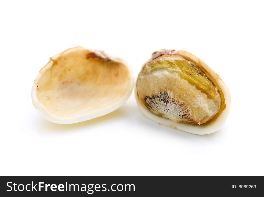 Pistachio nut peeled into half over white backgroud.