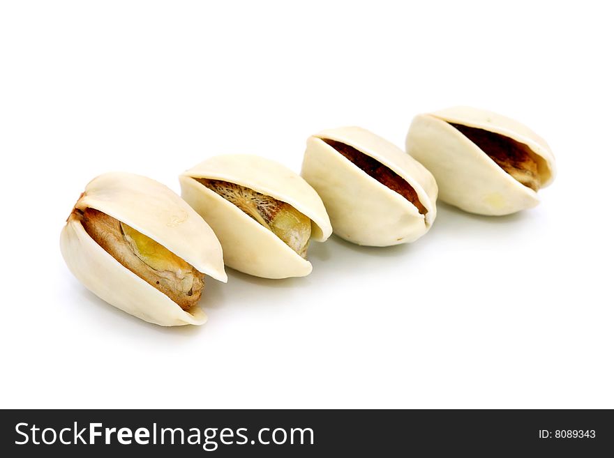 Four pistachio nuts arranged in a row over white background.