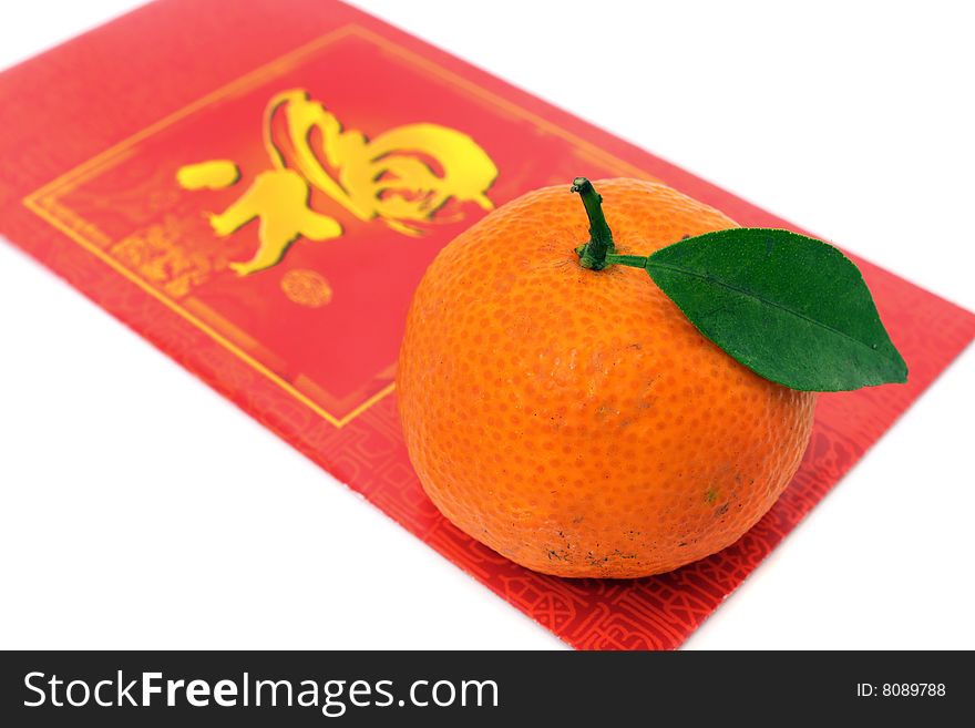 A mandarin oranges and red packet isolated over white background.