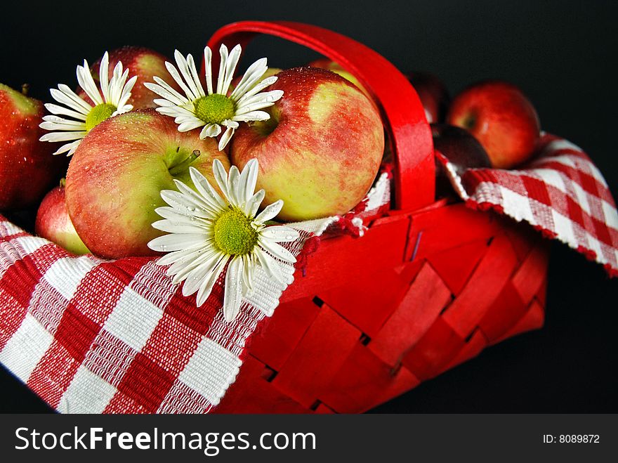 Daisies and apples in a red basket. Daisies and apples in a red basket.