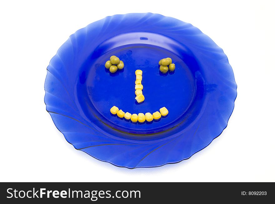 The Image of the person on a plate from a peas and corn. The Image of the person on a plate from a peas and corn