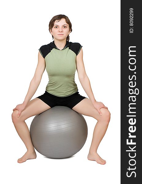 Young slim woman making fitness on a fit-ball isolated at the white background. Young slim woman making fitness on a fit-ball isolated at the white background