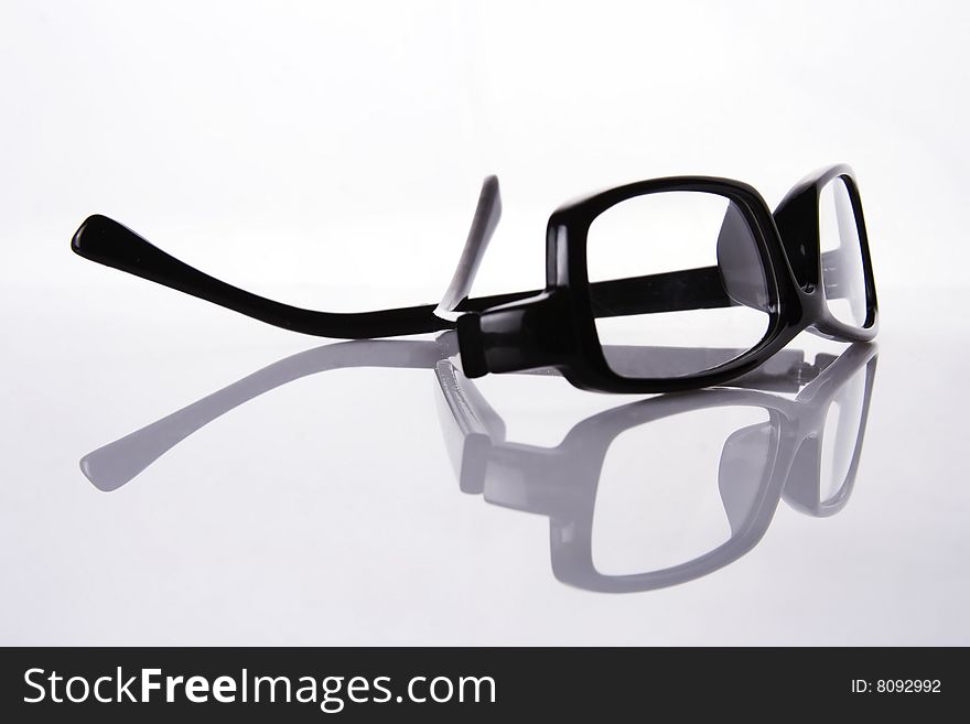 A black frame eyeglasses in plain white background with reflection.