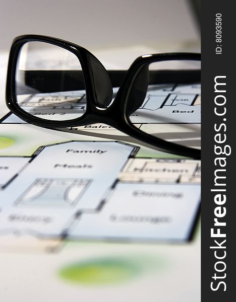 An architecture blueprint with black frame eyeglasses on top. An architecture blueprint with black frame eyeglasses on top.