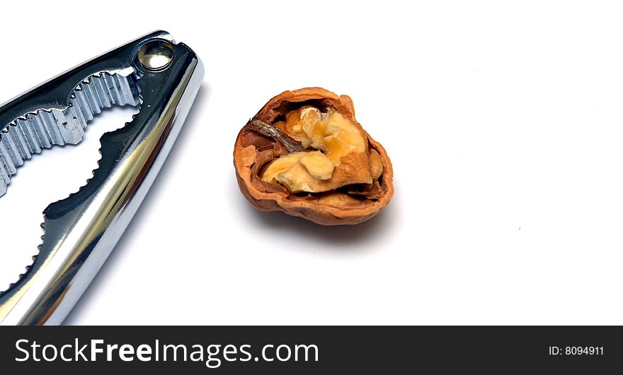 Photo of a nutcracker and an open walnut on a white background. Photo of a nutcracker and an open walnut on a white background