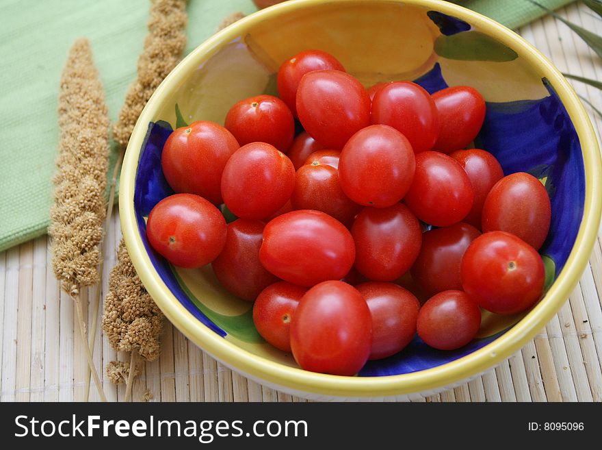 Some little tomatoes in a beautiful, bowl