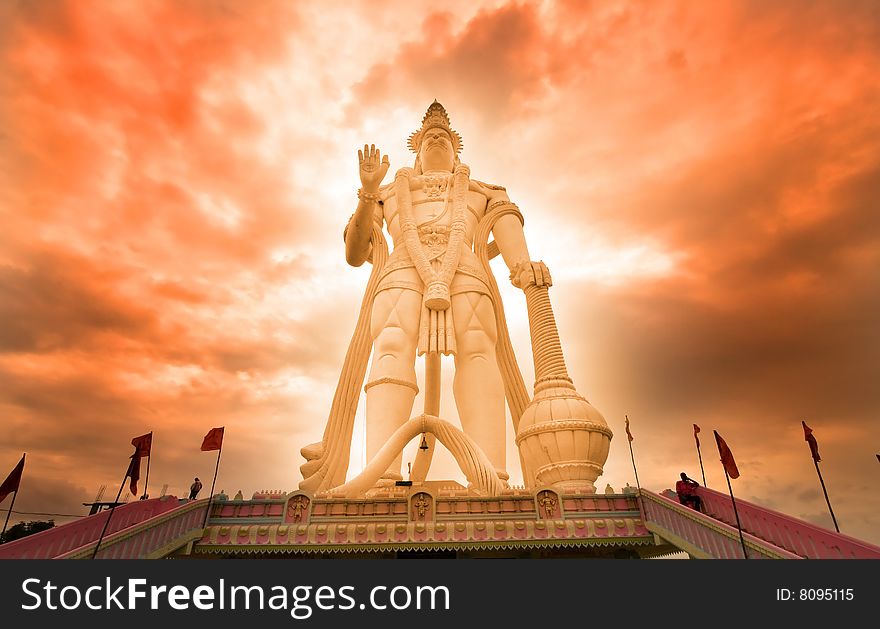 Hindu god Hanuman with cloudy red sky background