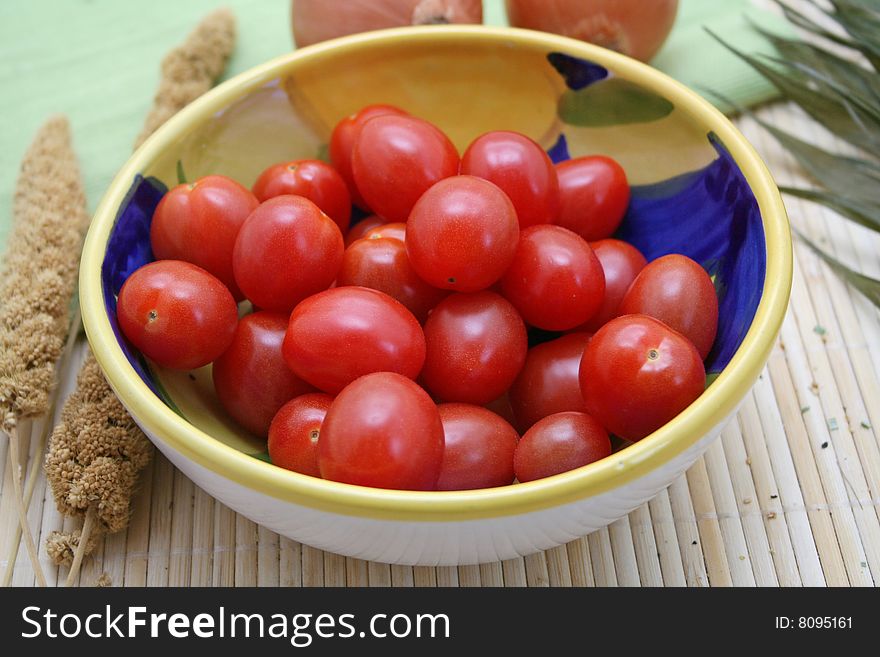 Some little tomatoes in a beautiful, bowl