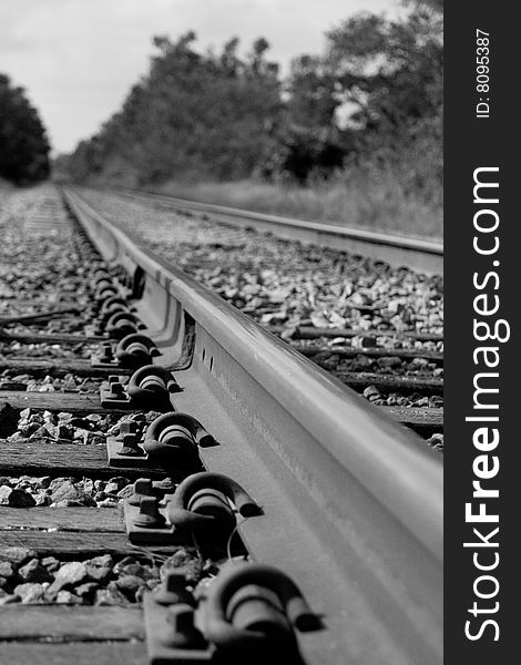 Railroad track in black and white showing detail.