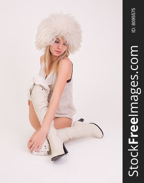 Upset young girl in furry hat, studio shot