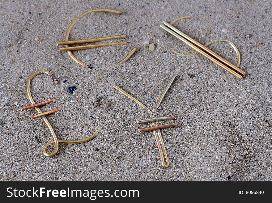 World money signs made from wire lying on sand background. World money signs made from wire lying on sand background