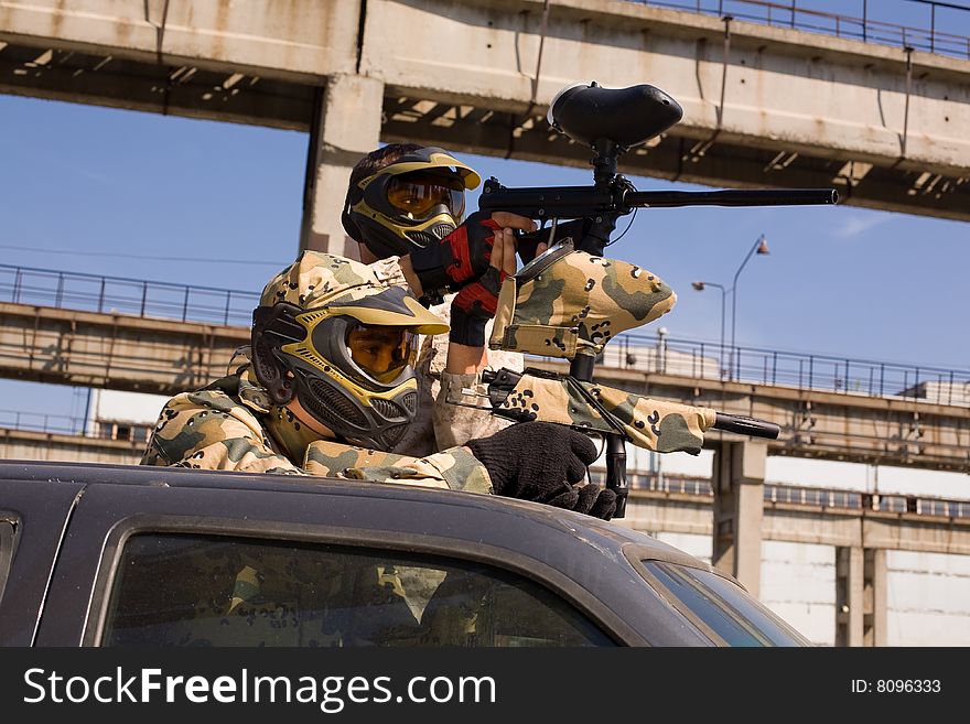 Two paintball players on the car