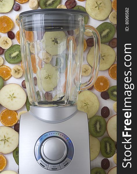 Empty silver blender in front of slit fruit background. Empty silver blender in front of slit fruit background