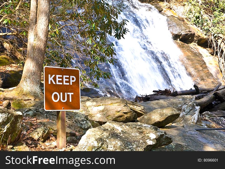 A keepout sign posted at a tourist area of a waterfall. A keepout sign posted at a tourist area of a waterfall.