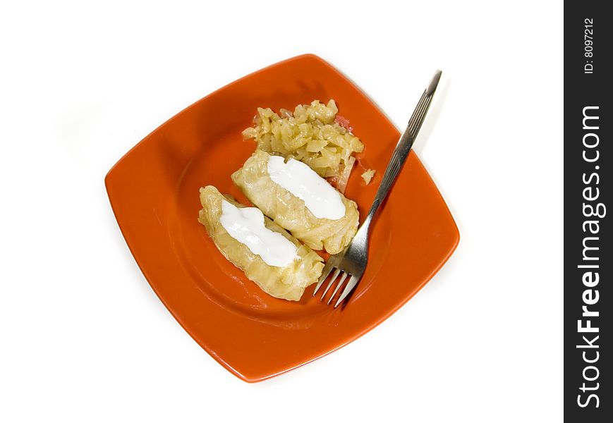 Stuffed cabbages with sour cream on red plate