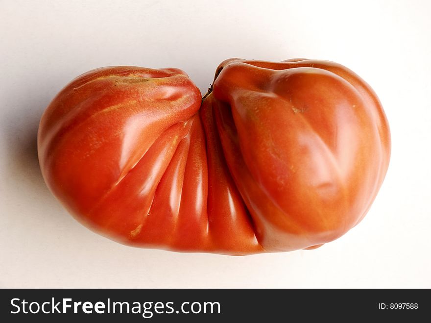 Deformed tomato on white with drop shadow