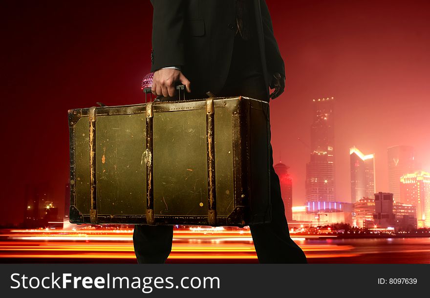 Man with vintage suitcase in a city on the night. Man with vintage suitcase in a city on the night