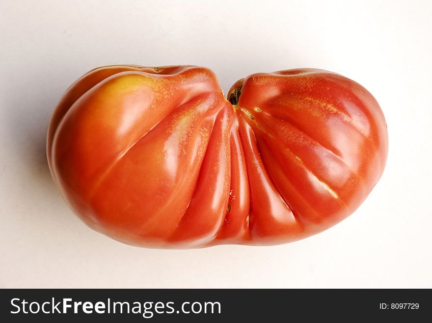 Deformed tomato on white with drop shadow