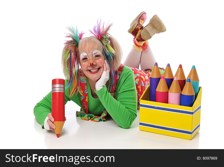 Clown with pencils smiling and lying down