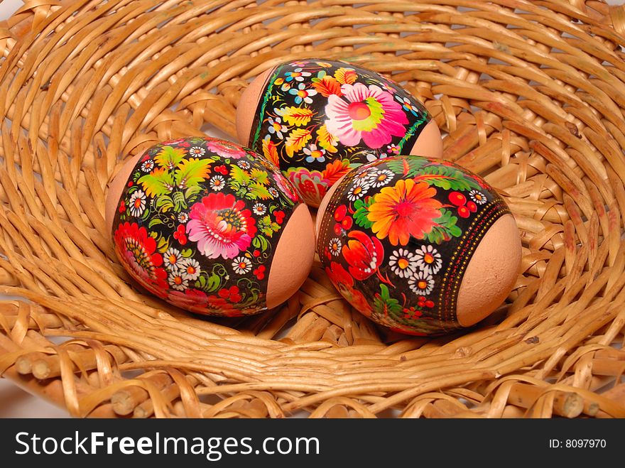 Three easter eggs are in a willow small basket