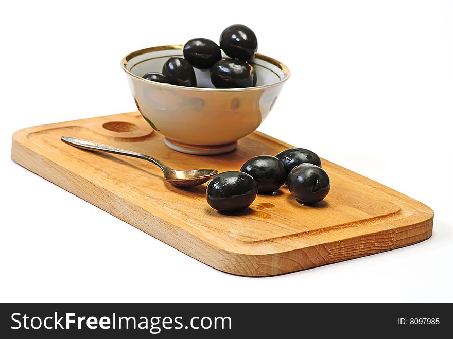 Olive in white cup on wooden plate