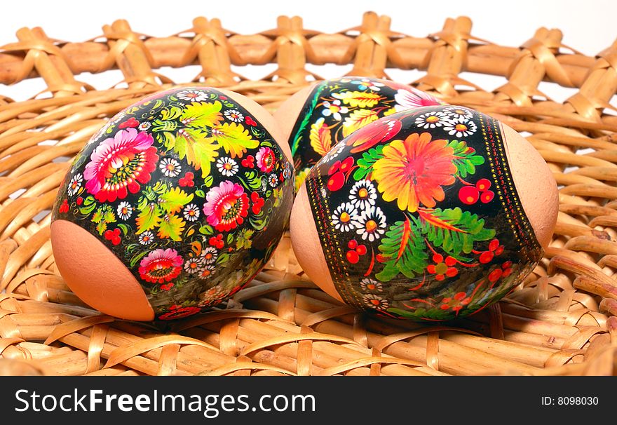 Three easter eggs are in a willow small basket