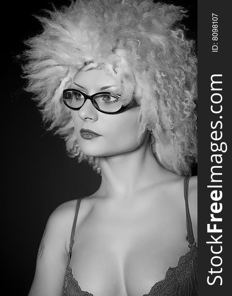 Girl in glasses and furry hat over black background, grayscale