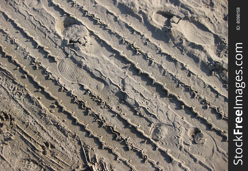 Footsteps and tire tracks on the beach. Footsteps and tire tracks on the beach