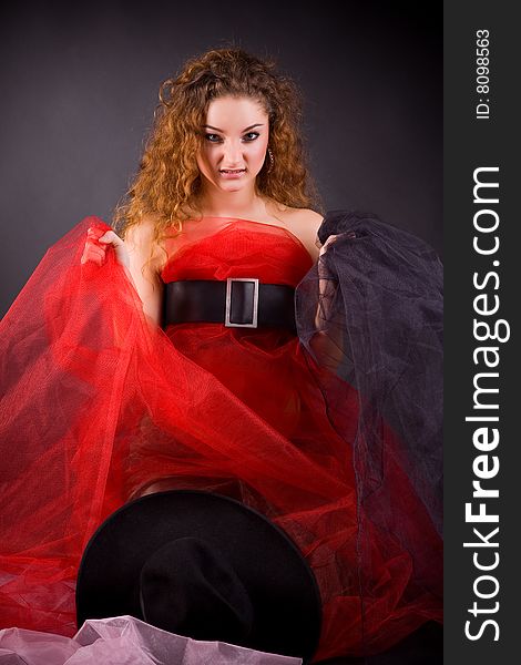 Unhappy red-haired girl over dark background