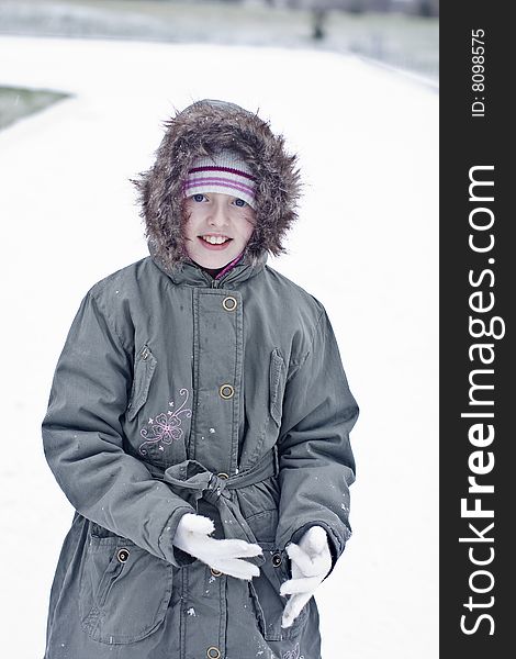 Mischievous girl wearing gloves in the snow