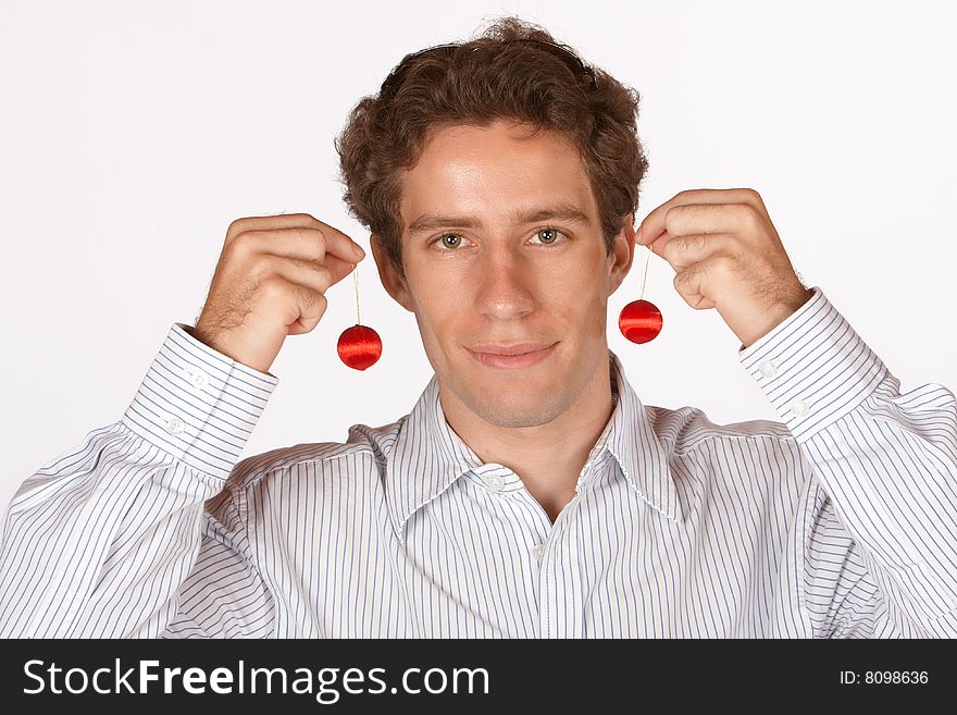 Young man holding up red decorations used for christmas