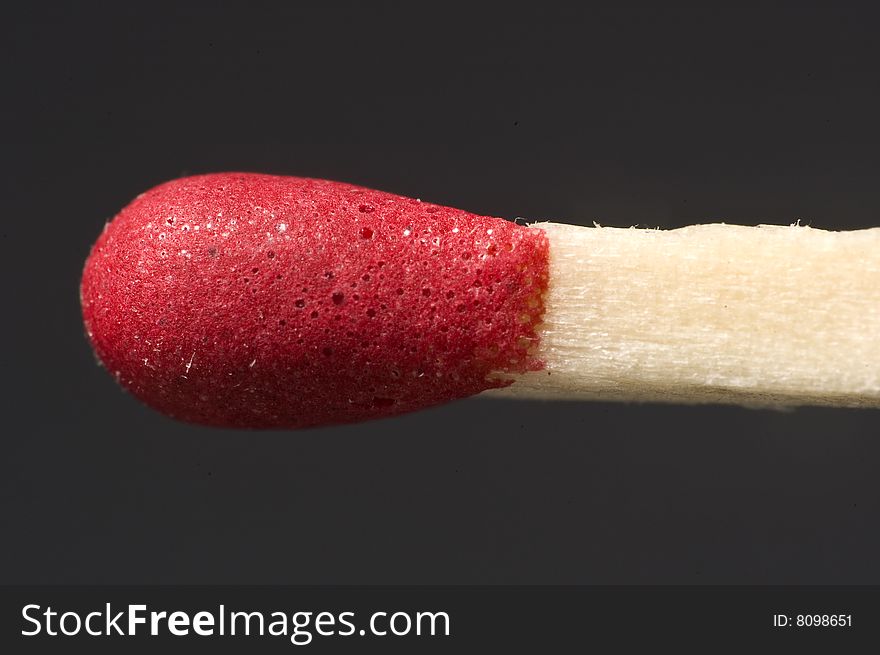 Red match head isolated on grey