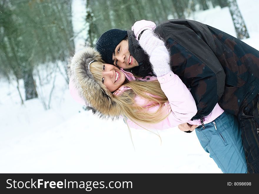 Happy young beautiful couple spending time in winter park. Happy young beautiful couple spending time in winter park