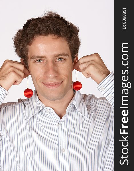 Young man using christmas decorations as ear rings. Young man using christmas decorations as ear rings