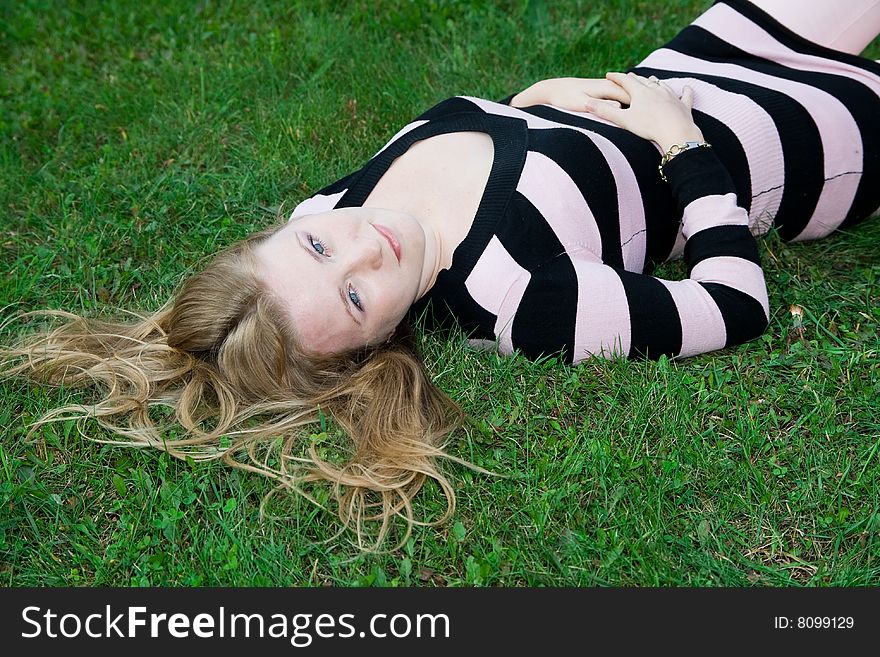 Beautiful girl lying on green grass