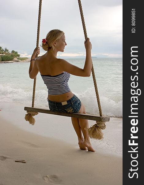 Girl on rope swings at the beach