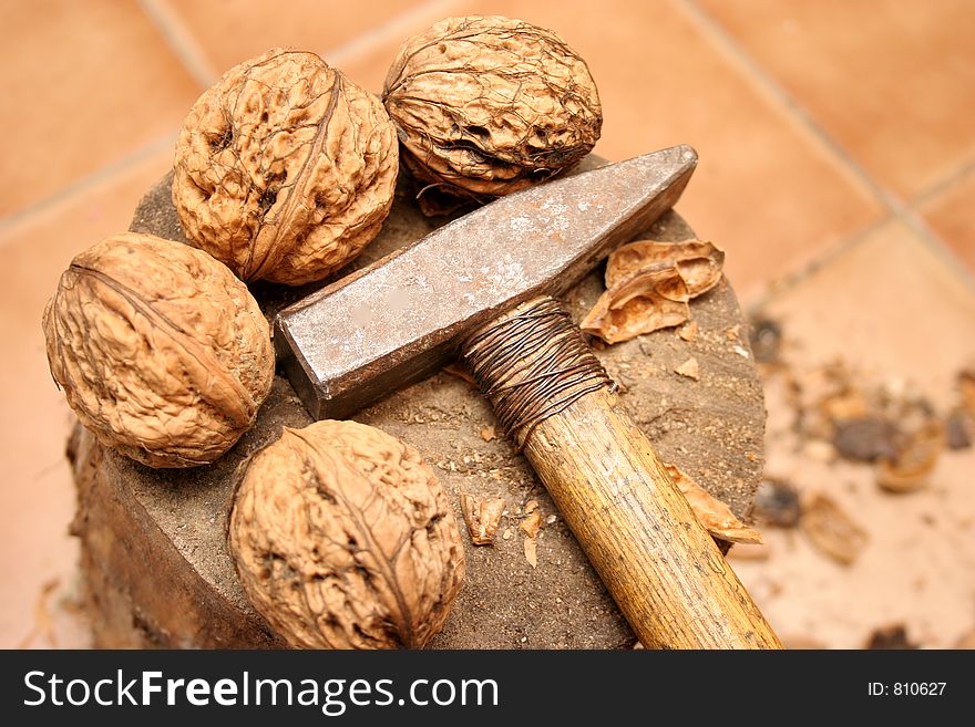 Big walnuts and hammer with wood