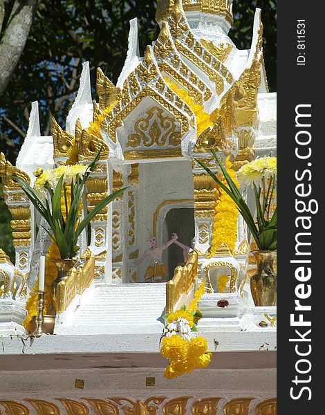 Detail of white and gold spirit house among trees in Thailand. Detail of white and gold spirit house among trees in Thailand