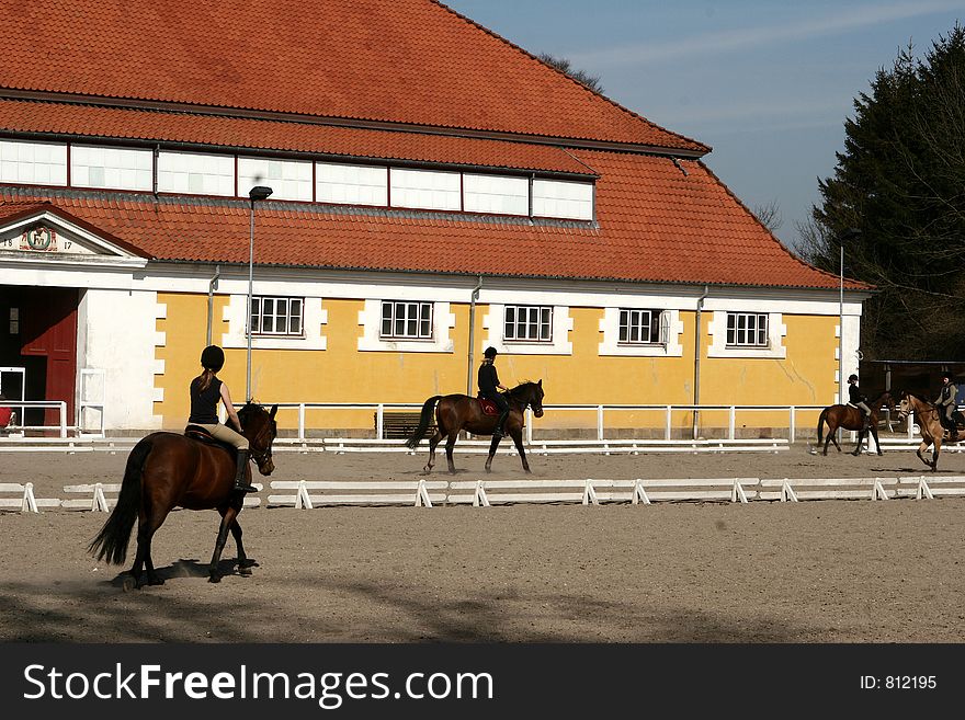 Teen danish girls on horses on a field in the summer, beautiful buiding in the background. Teen danish girls on horses on a field in the summer, beautiful buiding in the background