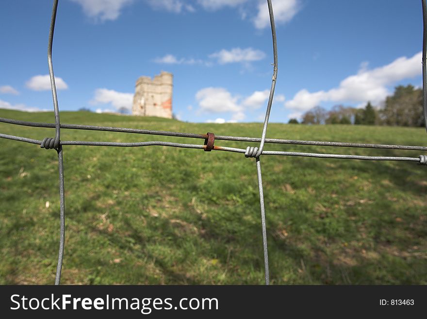 The ruins of Donnington Castle, Newbury, UK, seen through a rusty wire fence. The ruins of Donnington Castle, Newbury, UK, seen through a rusty wire fence