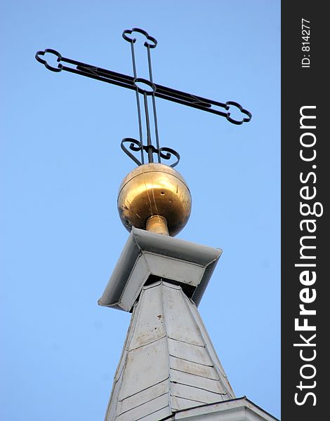 Cross on church spire against a clear blue sky