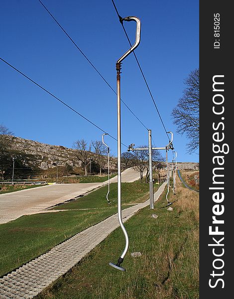 Deserted dry ski slope showing ski lifts