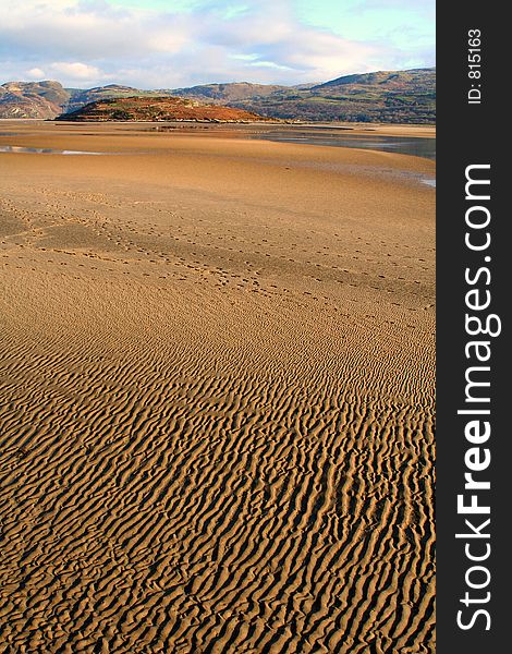 Deserted sandy beach with distant hills