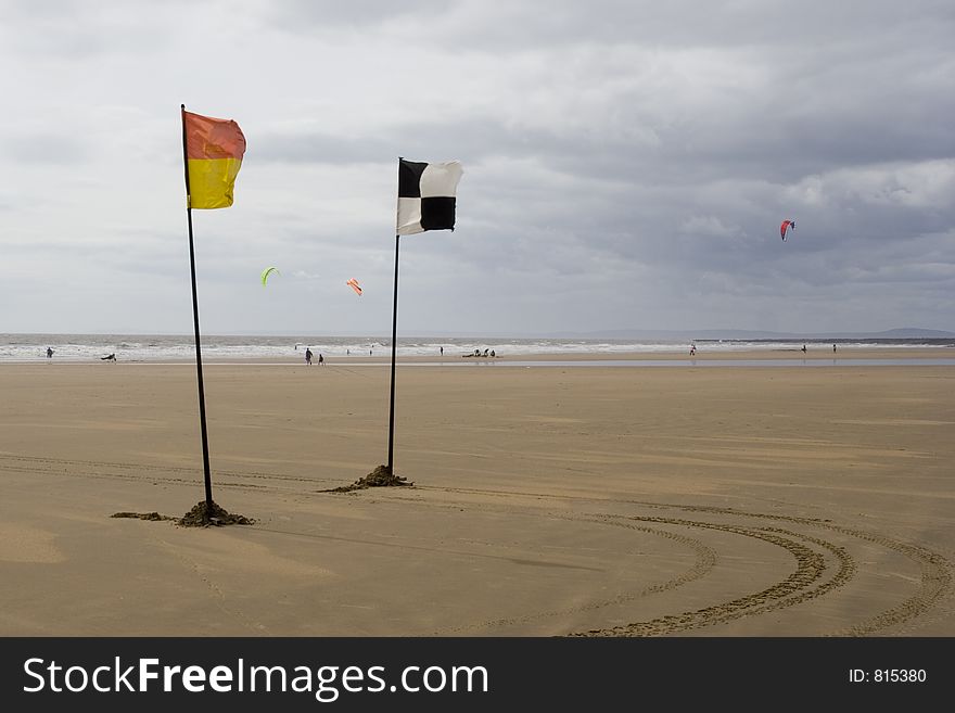 Yellow and red and chequered flags flying on beach. Life savers warning signs. Yellow and red and chequered flags flying on beach. Life savers warning signs.