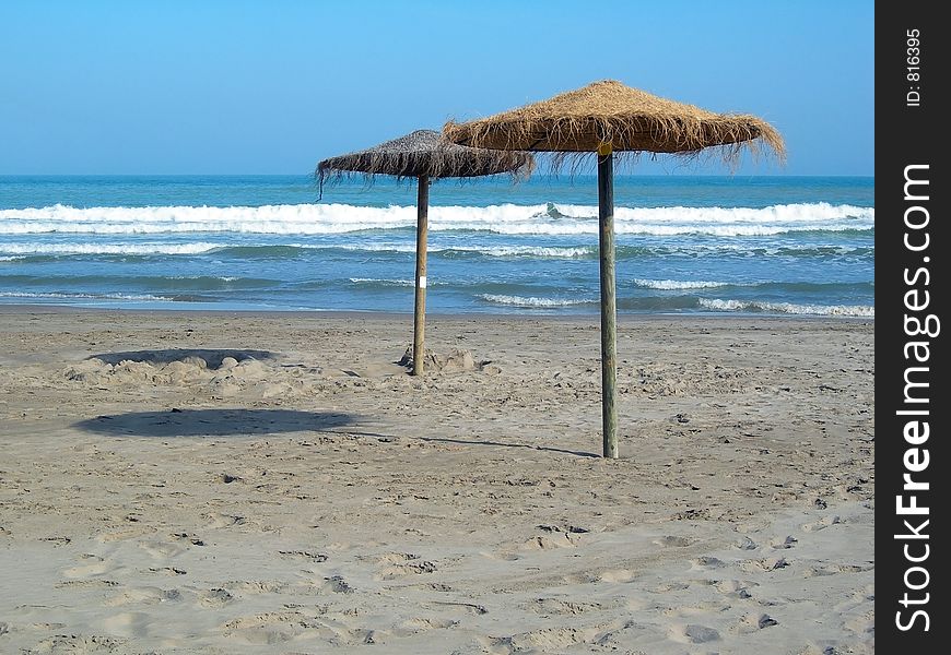 Two beach umbrellas in the sand