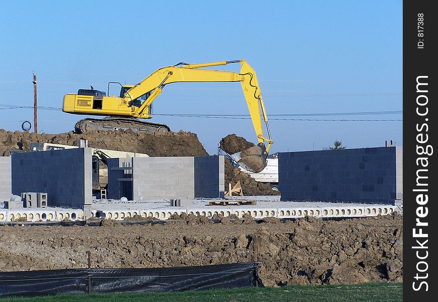 A picture of a large backhoe at a construction site. A picture of a large backhoe at a construction site.