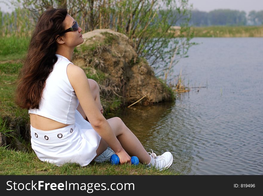 Fitness Girl Relaxing Near A Lake