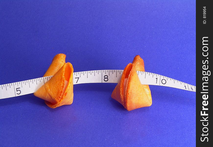 Two fortune cookies and a measuring tape (counting your fortunes). Two fortune cookies and a measuring tape (counting your fortunes)