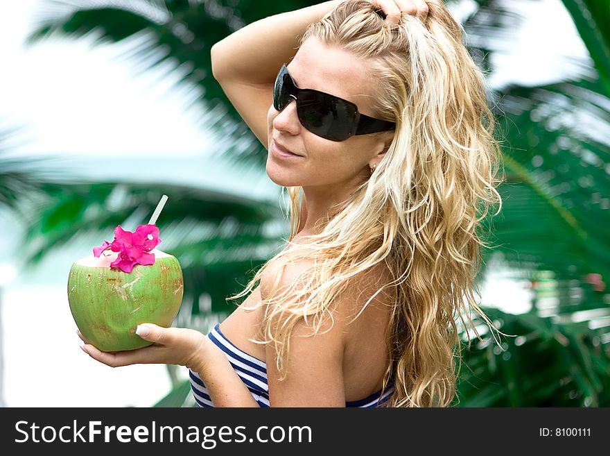 Girl holding coconut and palm on the background. Girl holding coconut and palm on the background