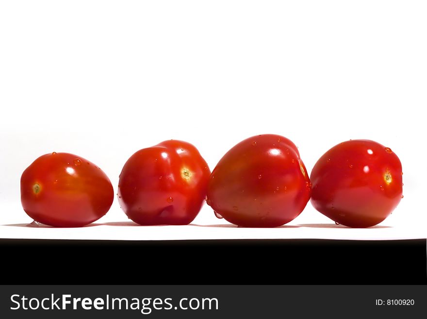 Four small tomatoes against white and black. Four small tomatoes against white and black